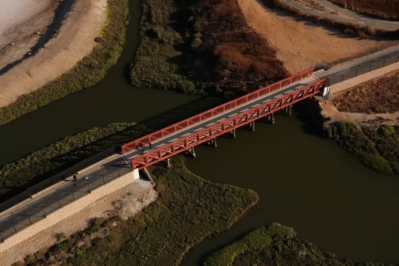 A bridge over water with trees in the background