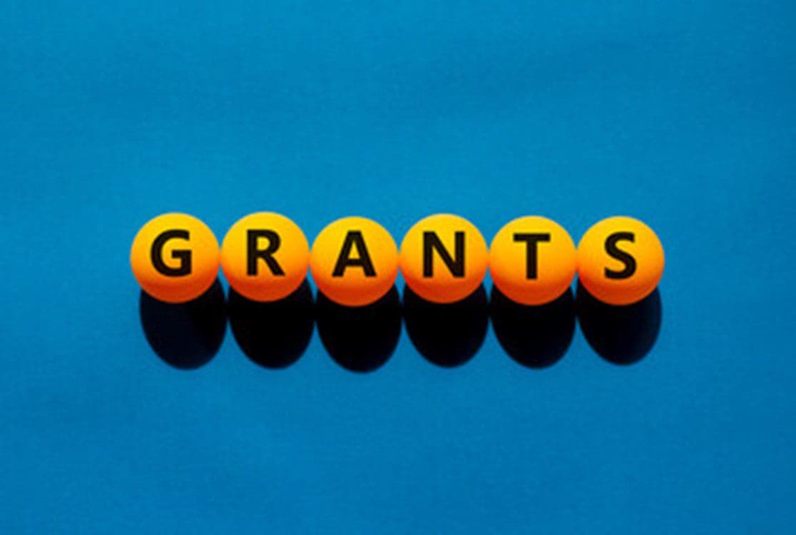 A blue table with orange balls spelling out the word " grants ".