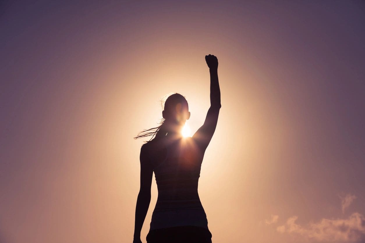 A woman raises her fist in the air.