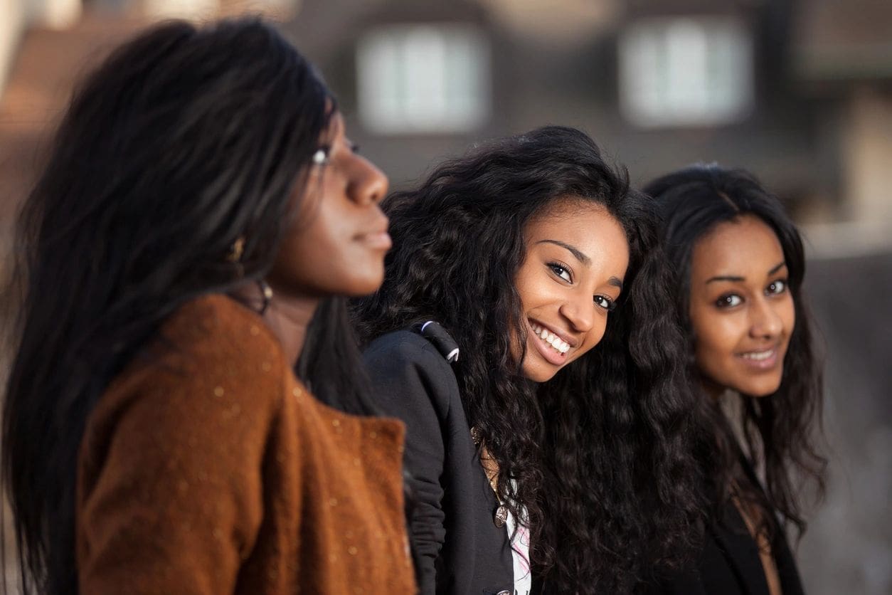 Three women are smiling and posing for a picture.